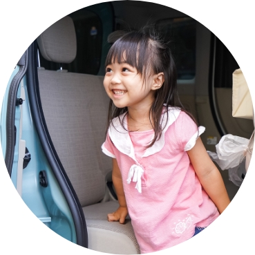 送迎車に乗る子どもが安心した表情を見せている様子